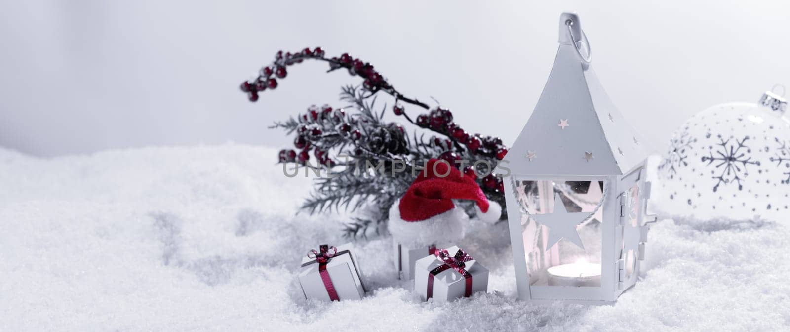 Christmas holidays card with gifts , balls , and white glowing lantern in snow