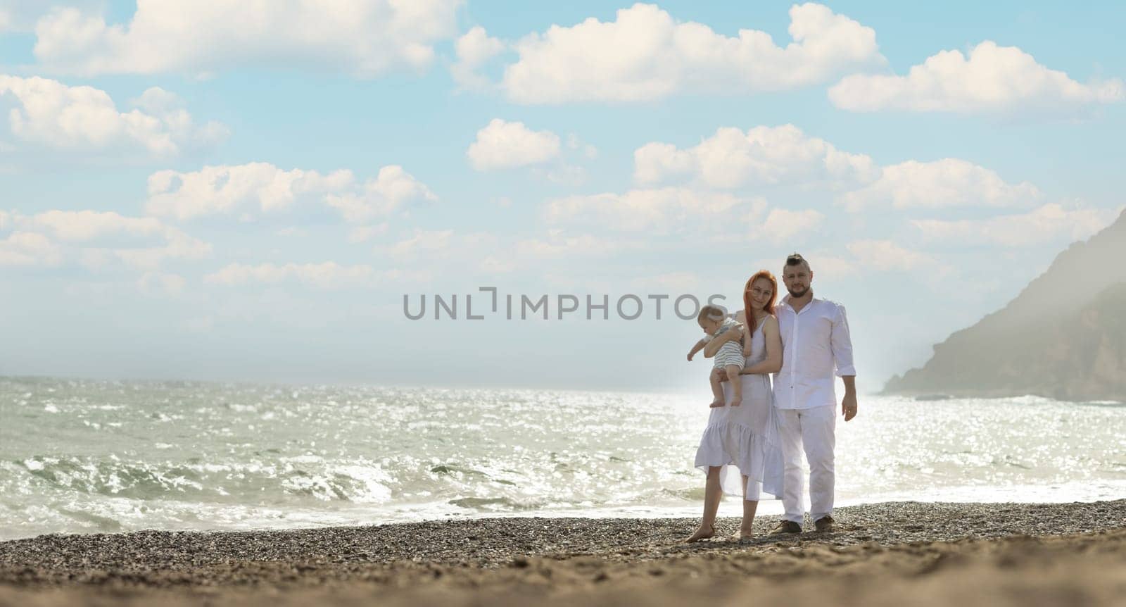 Happy family on vacation - standing on the beach with little baby son by Studia72