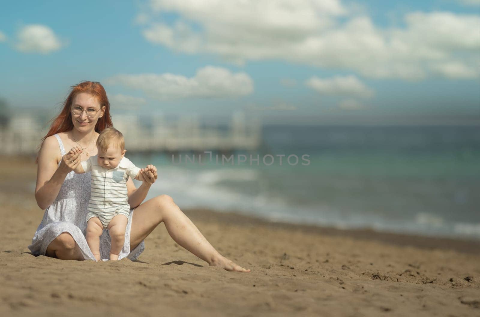 Happy mother and her little son resting on the seaside by Studia72