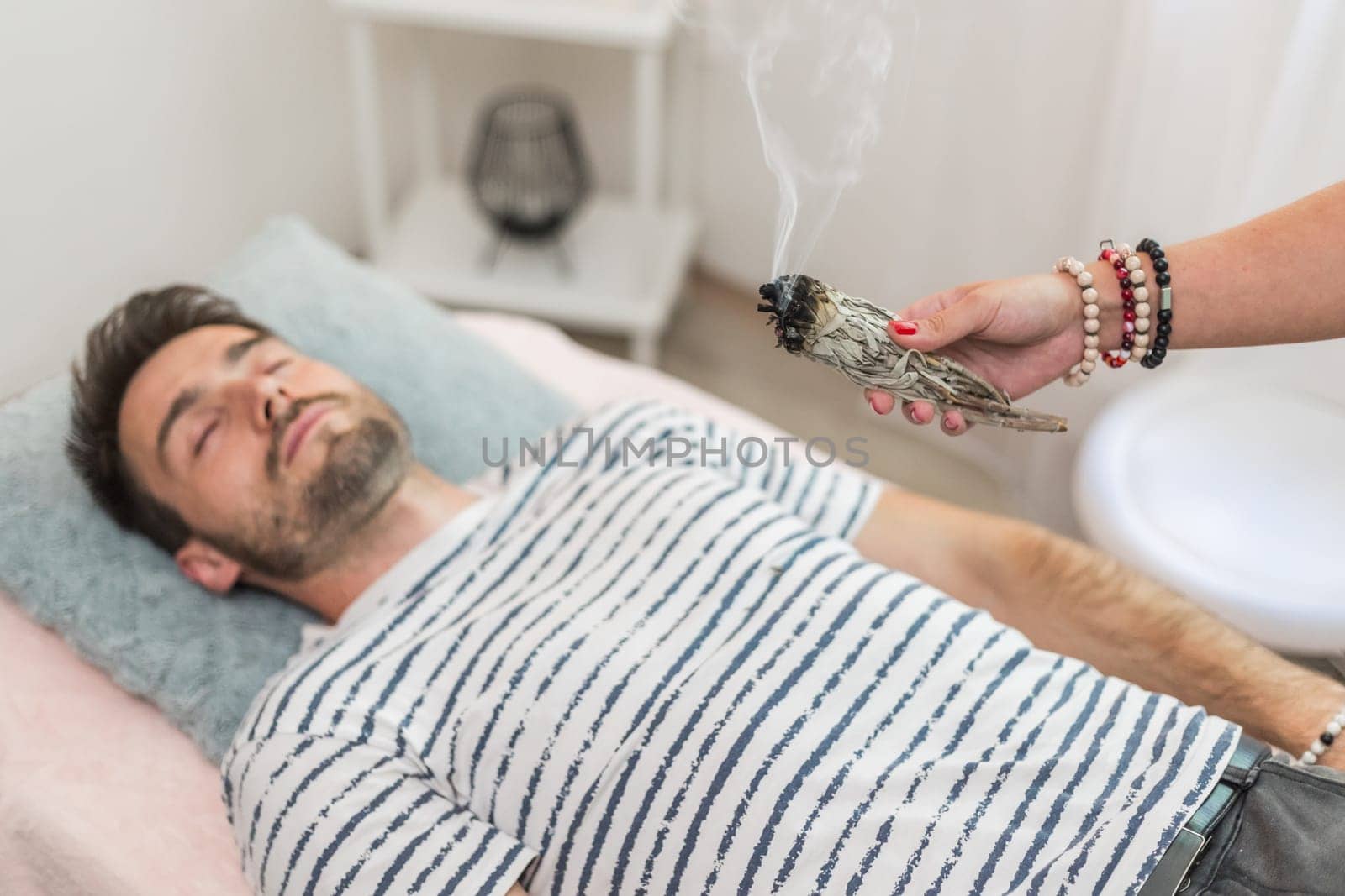 Woman healer doing aromatherapy by smoldering sage, alternative medicine