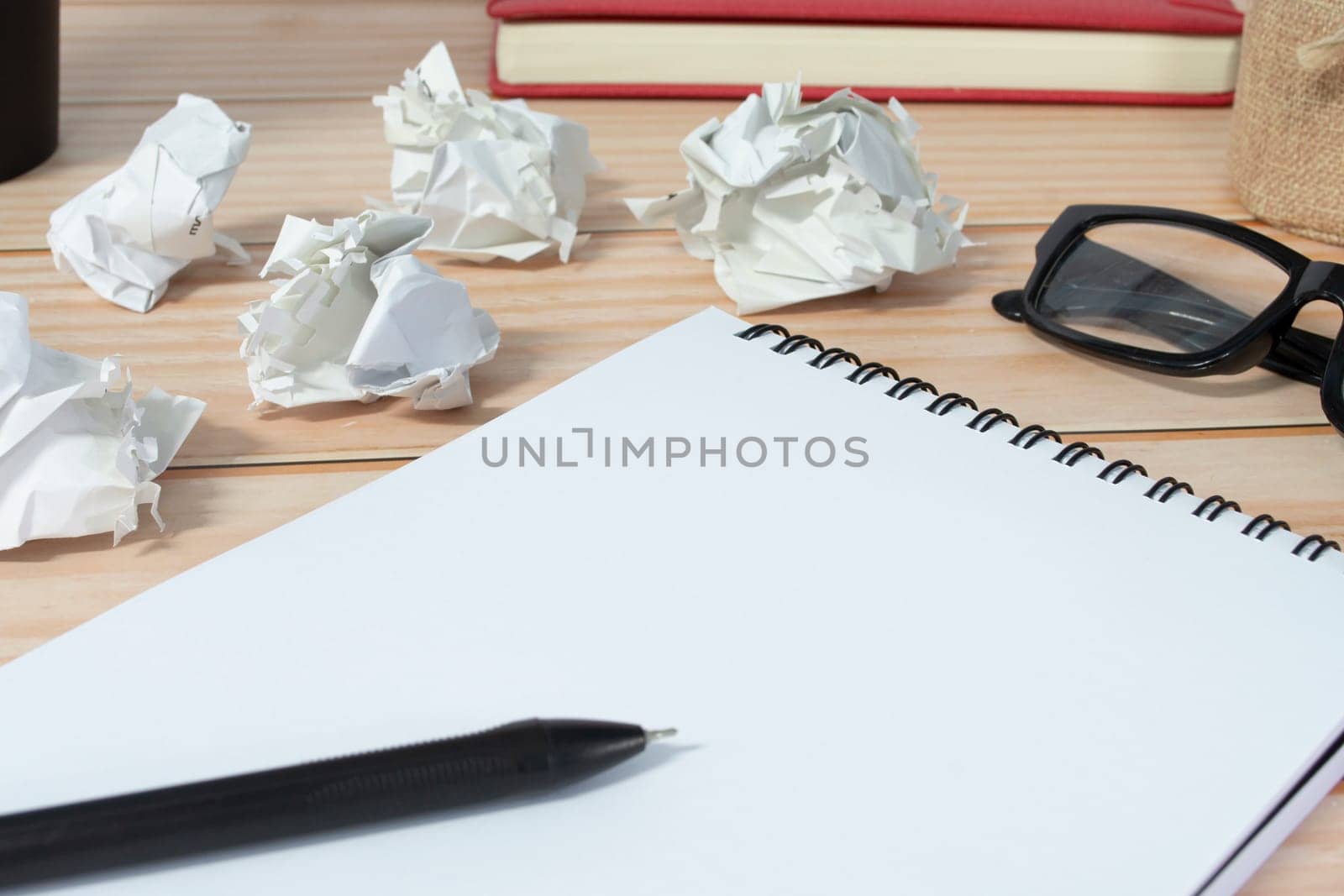 Notepad with trash paper background on wooden desk. Copy space.