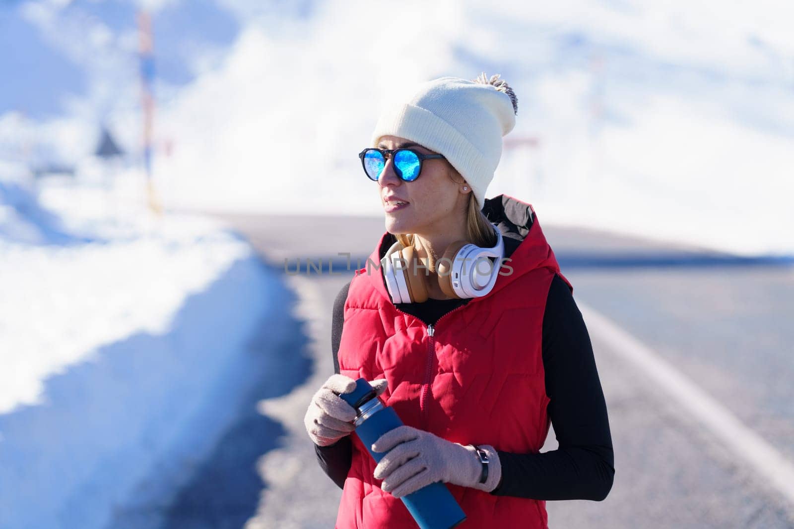 Sportive woman with water bottle in winter nature by javiindy