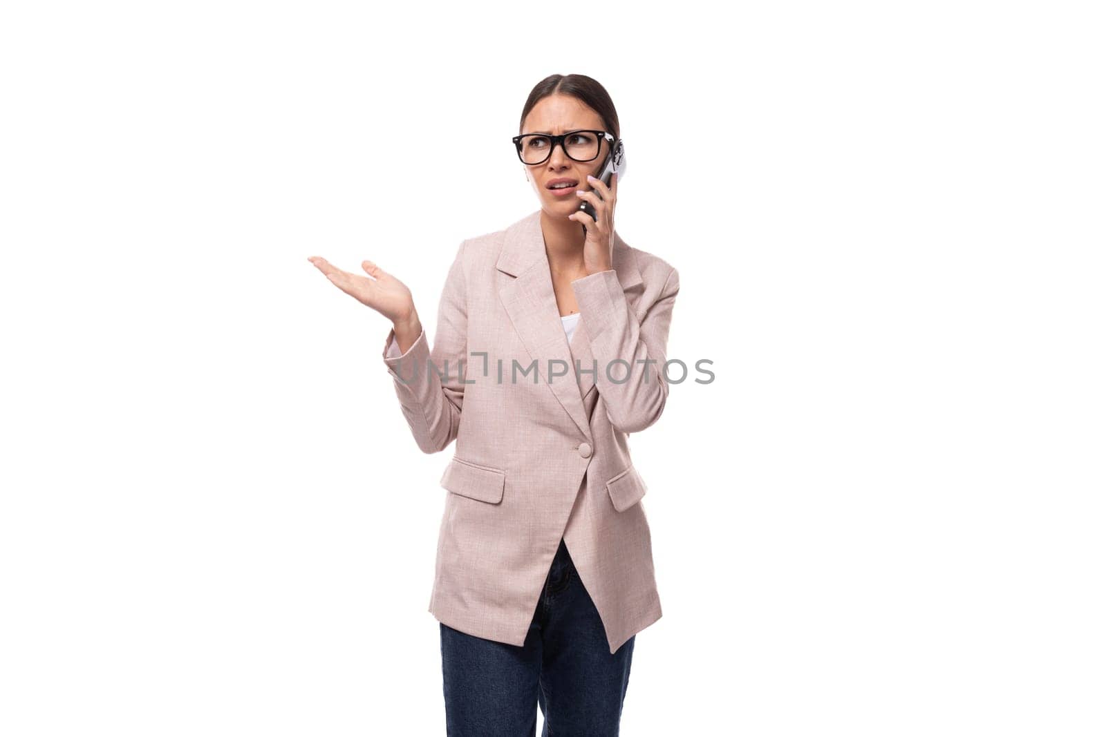 young smart brunette with hair gathered in a ponytail is dressed in a light jacket on a white background with copy space by TRMK