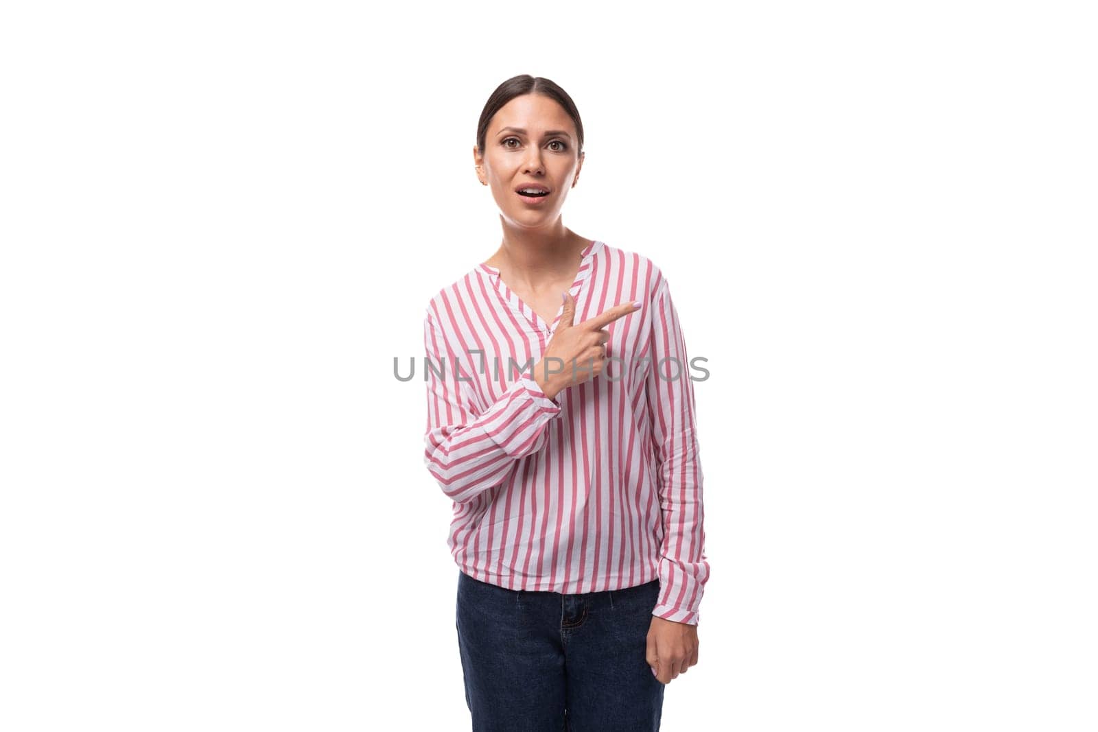 young brunette office worker woman dressed in a shirt points with her hands to the space for advertising by TRMK