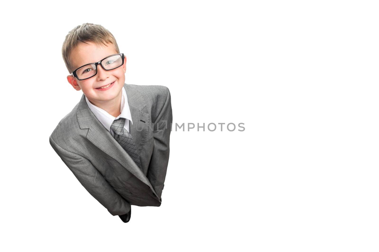 Small child dressed in a business suit and glasses as a businessman, top view. Child in his fathers suit isolated on white background.