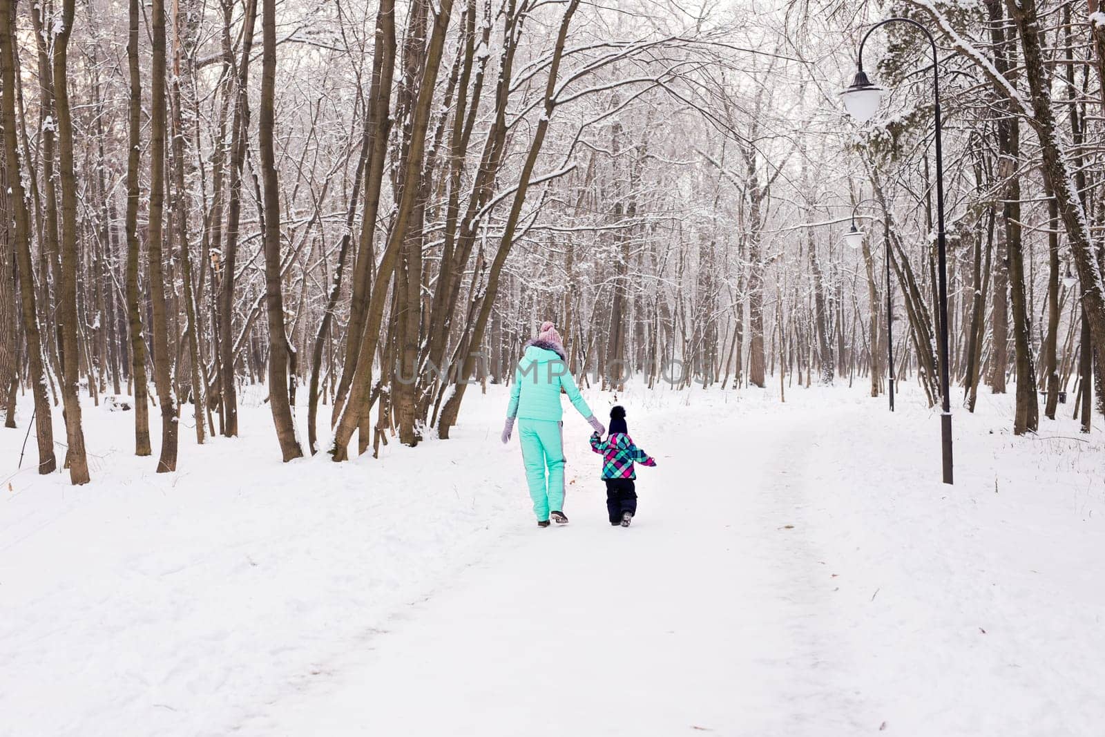 happy family mother and child baby daughter on a winter walk in the woods.