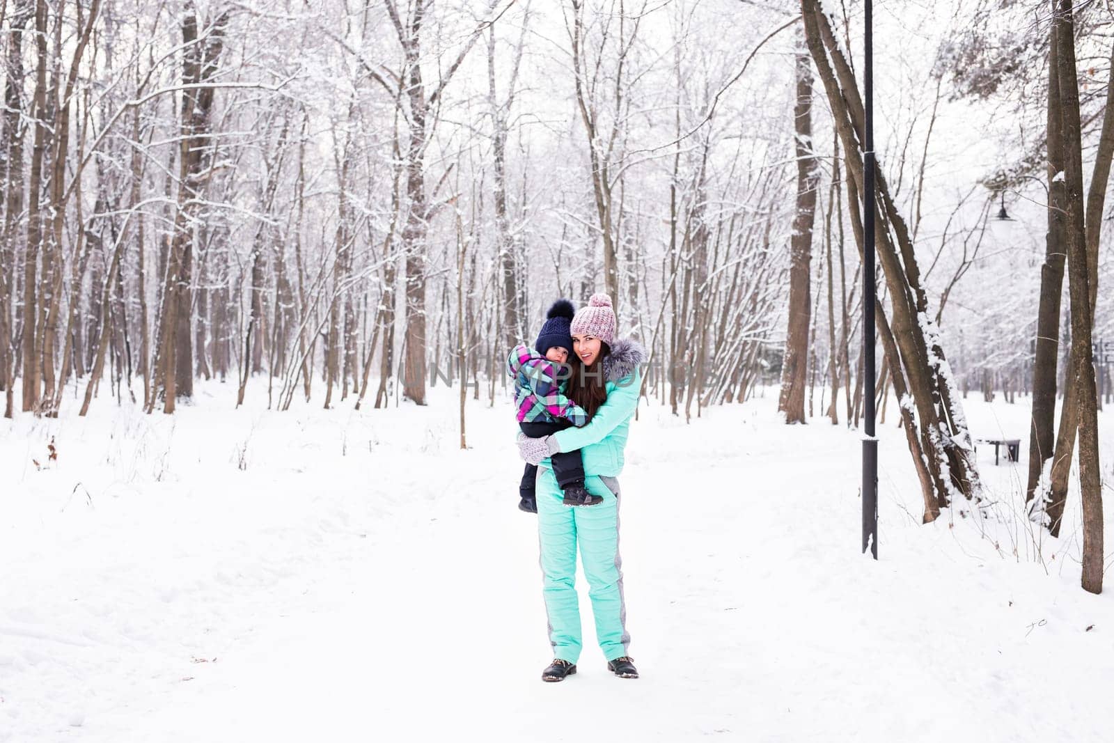 happy family mother and child baby daughter on a winter walk in the woods.