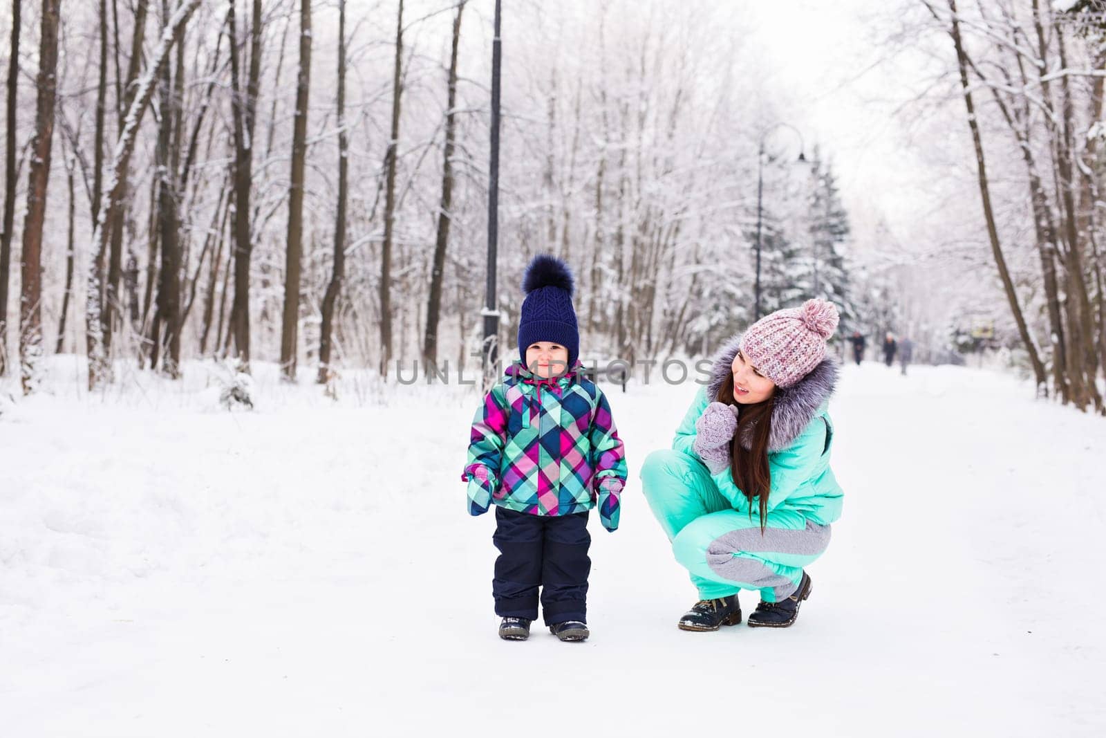 happy family mother and child baby daughter on a winter walk in the woods.