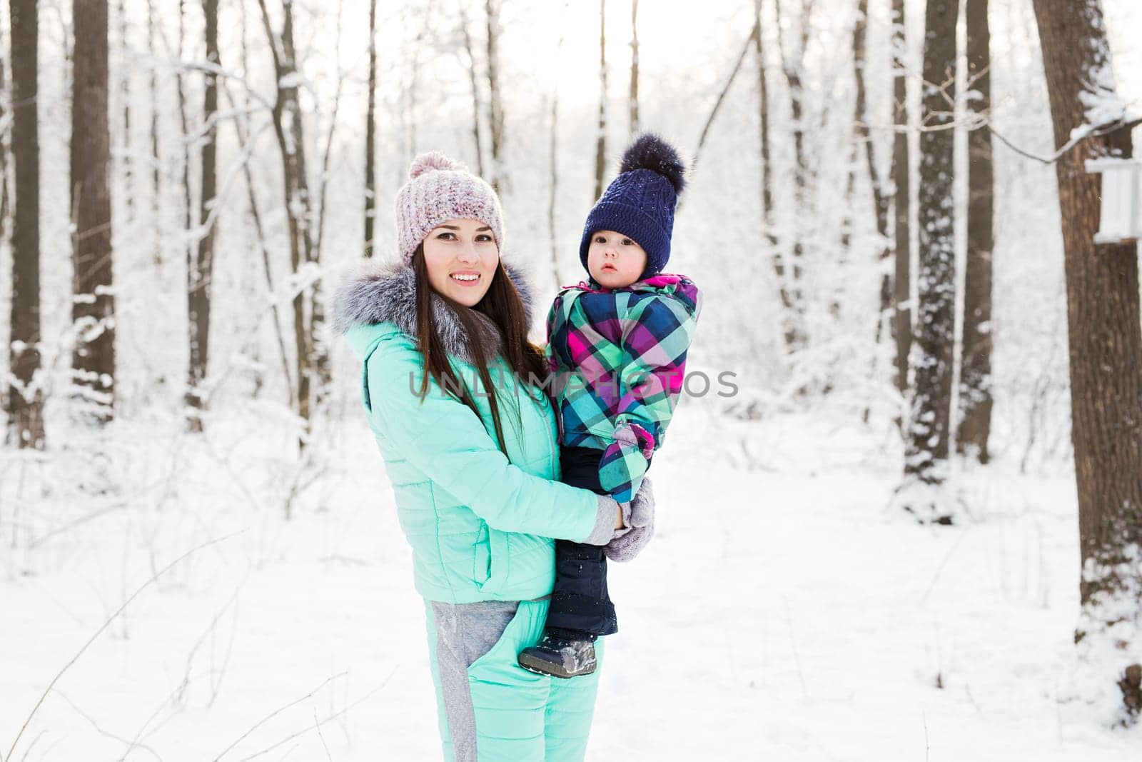 happy family mother and child baby daughter on a winter walk in the woods.