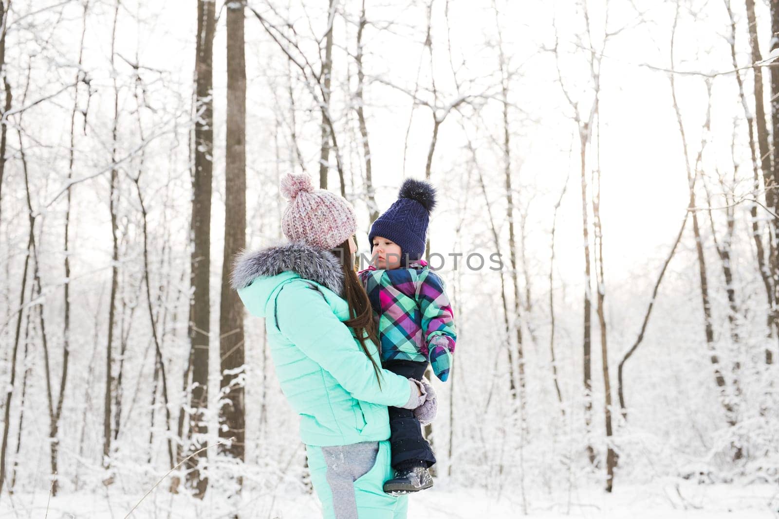 happy family mother and child baby daughter on a winter walk in the woods.