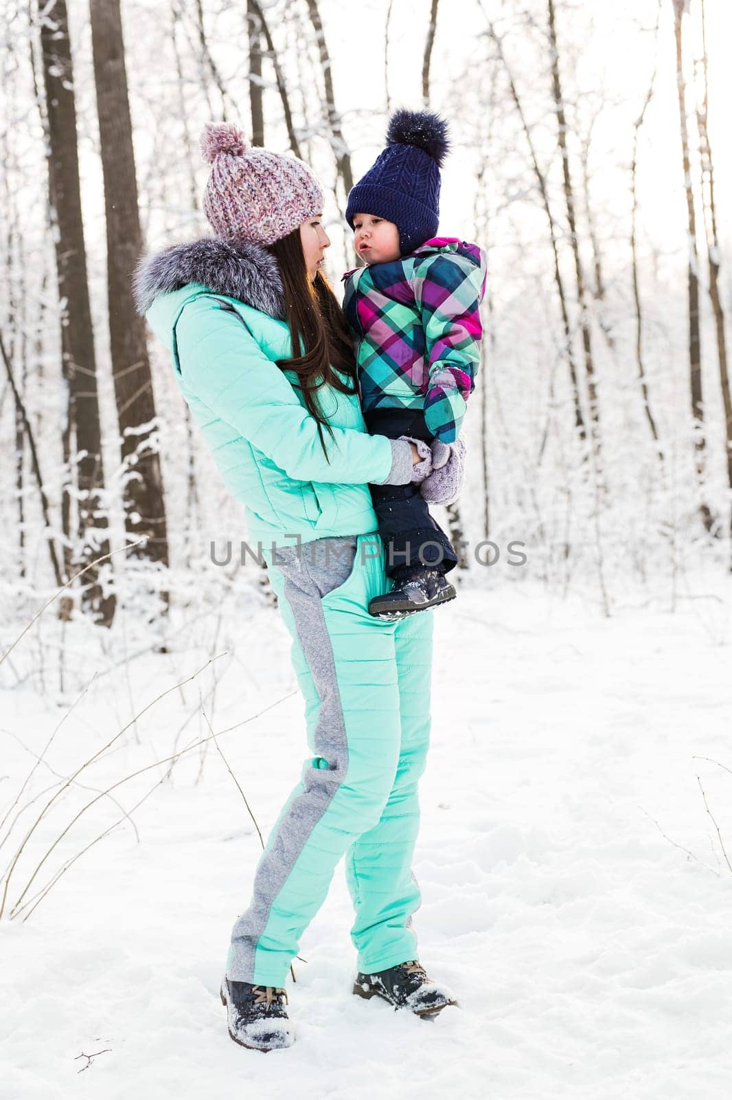 happy family mother and child baby daughter on a winter walk in the woods by Satura86