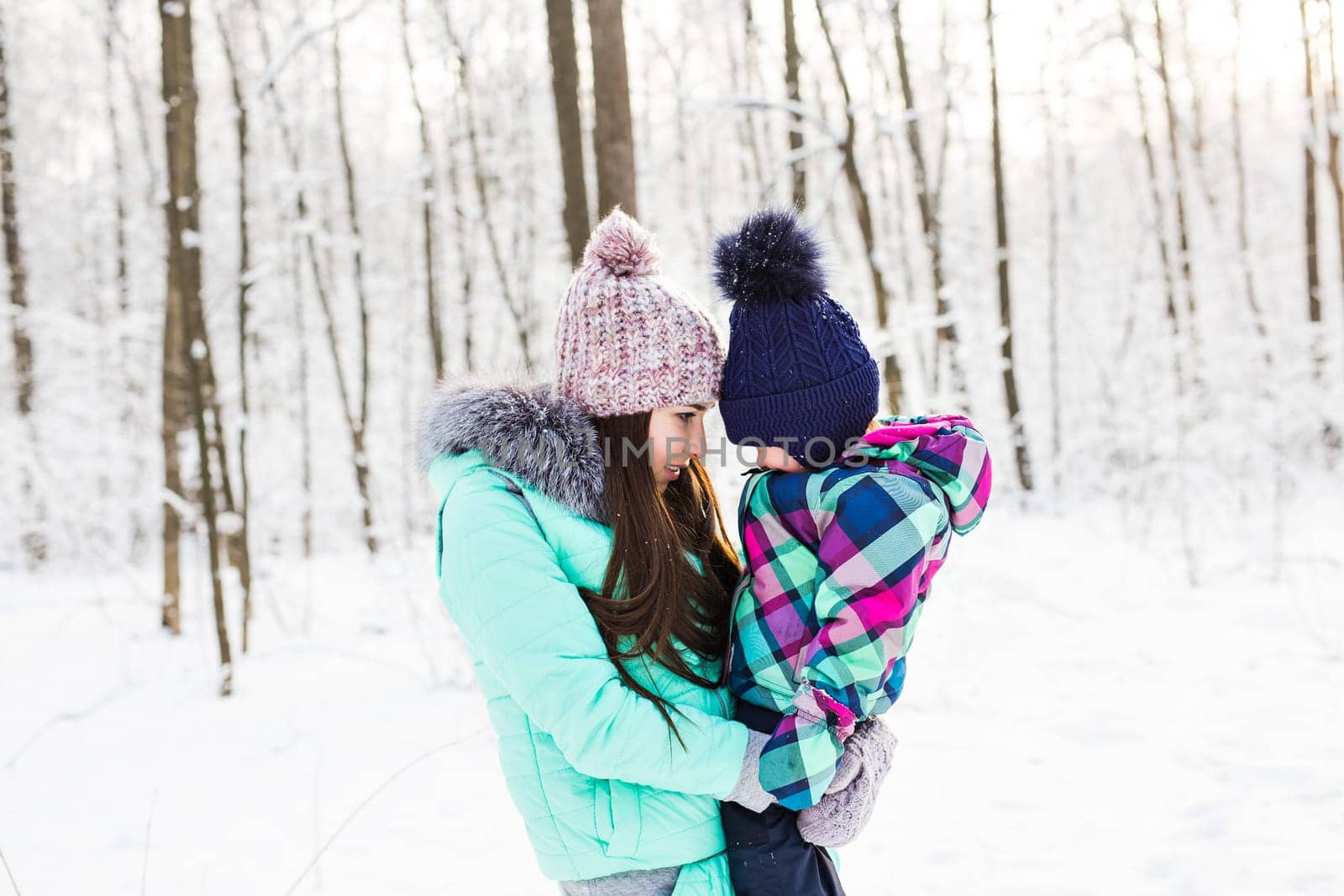 happy family mother and child baby daughter on a winter walk in the woods.