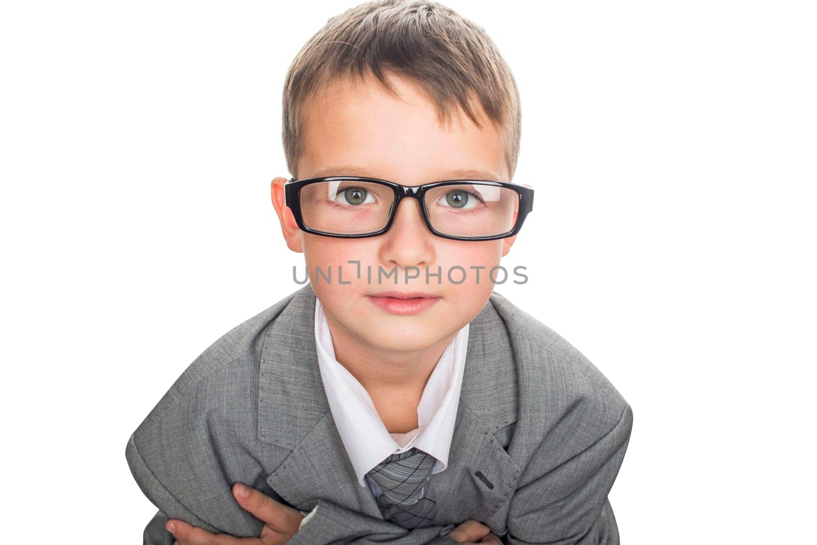 Portrait of a cute schoolboy in businessman suit and glasses, isolated on white. Handsome child boy in business suit.