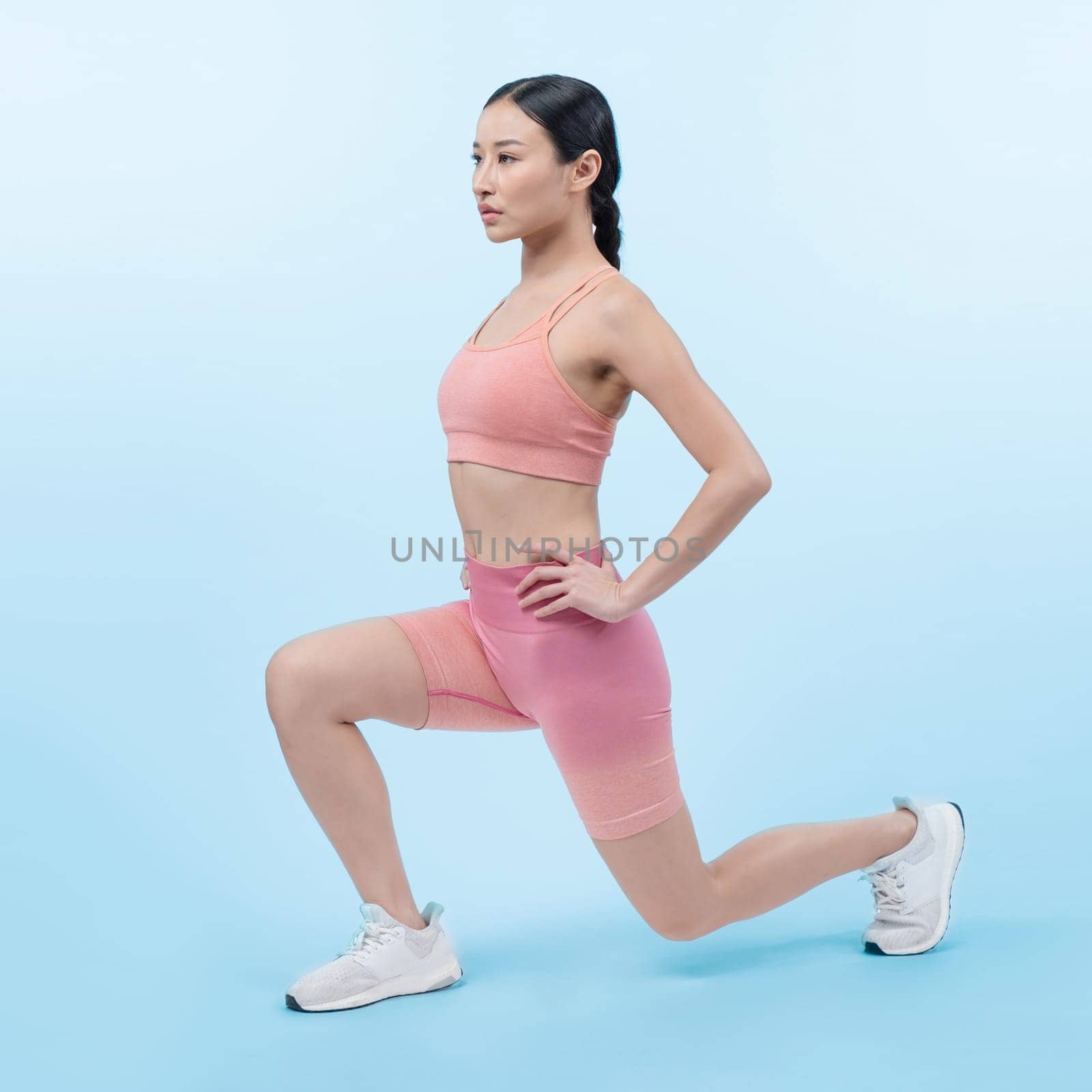 Young attractive asian woman in sportswear stretching before fitness exercise routine. Healthy body care workout with athletic woman warming up on studio shot isolated background. Vigorous