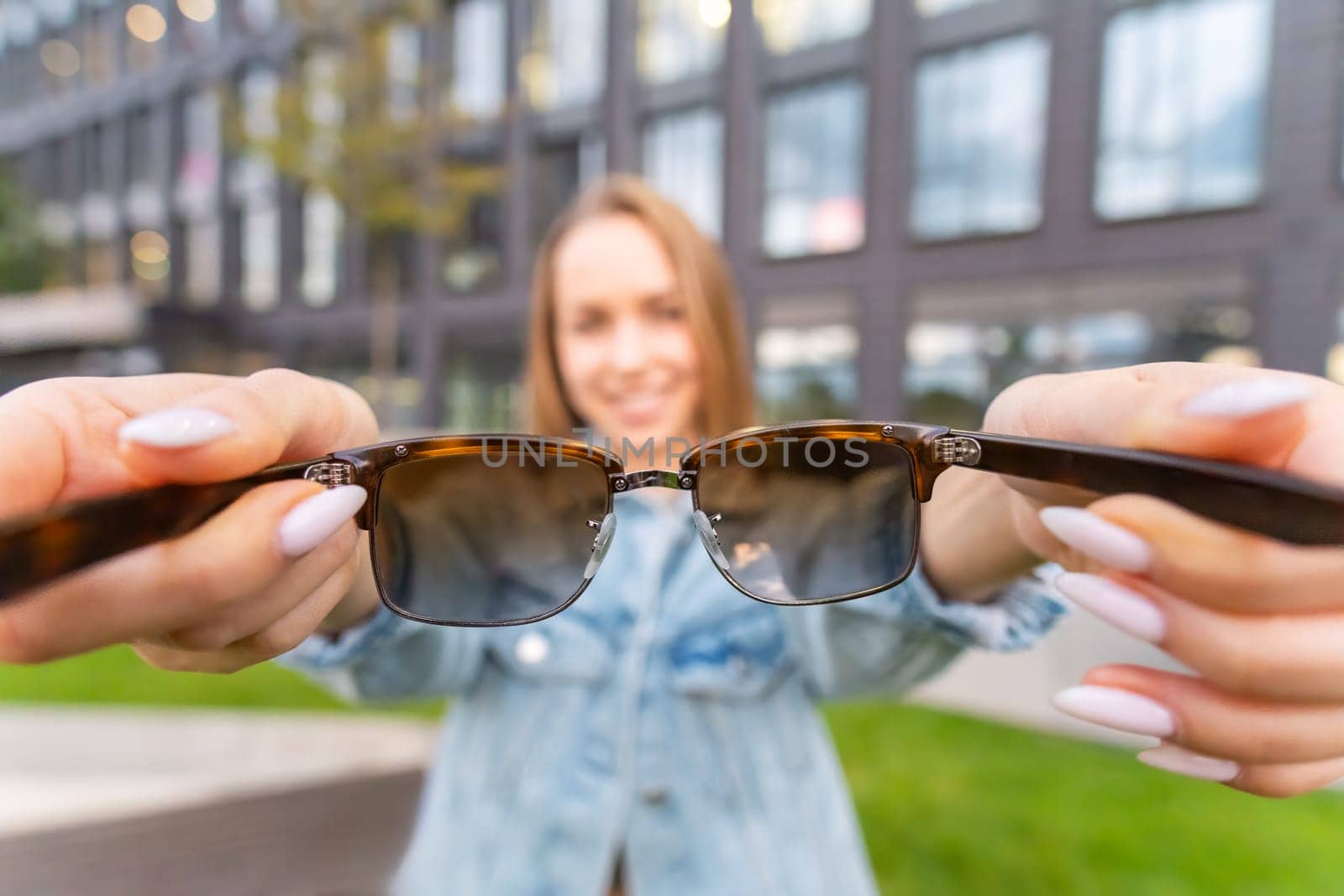 Attractive young blonde woman with long hair proposed to wear smart sunglasses.