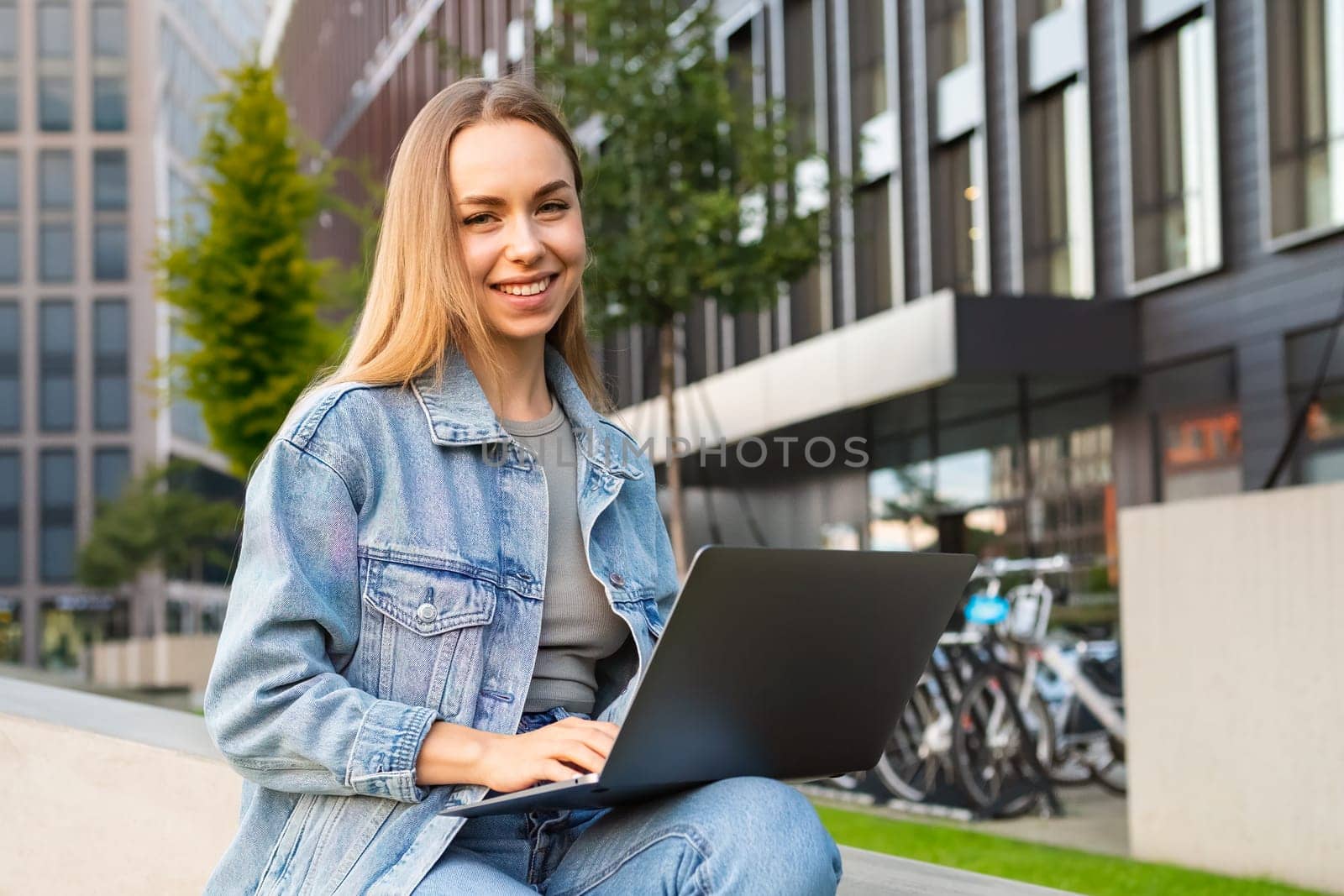 Young woman takes her freelance work to the streets, enjoying the flexibility and urban atmosphere.