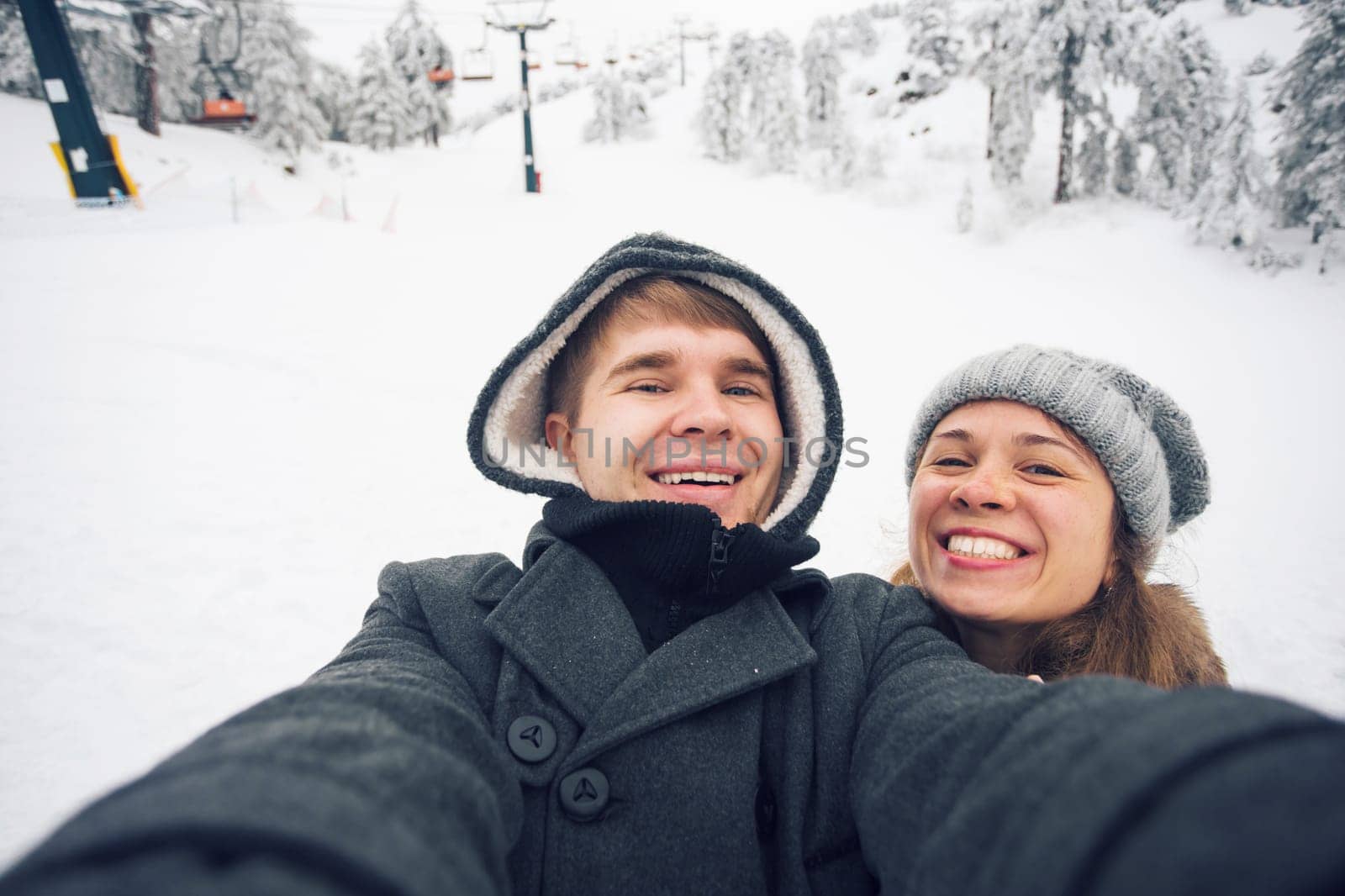 Young and happy couple doing winter selfie outdoor. Christmas, New Year and people concept by Satura86
