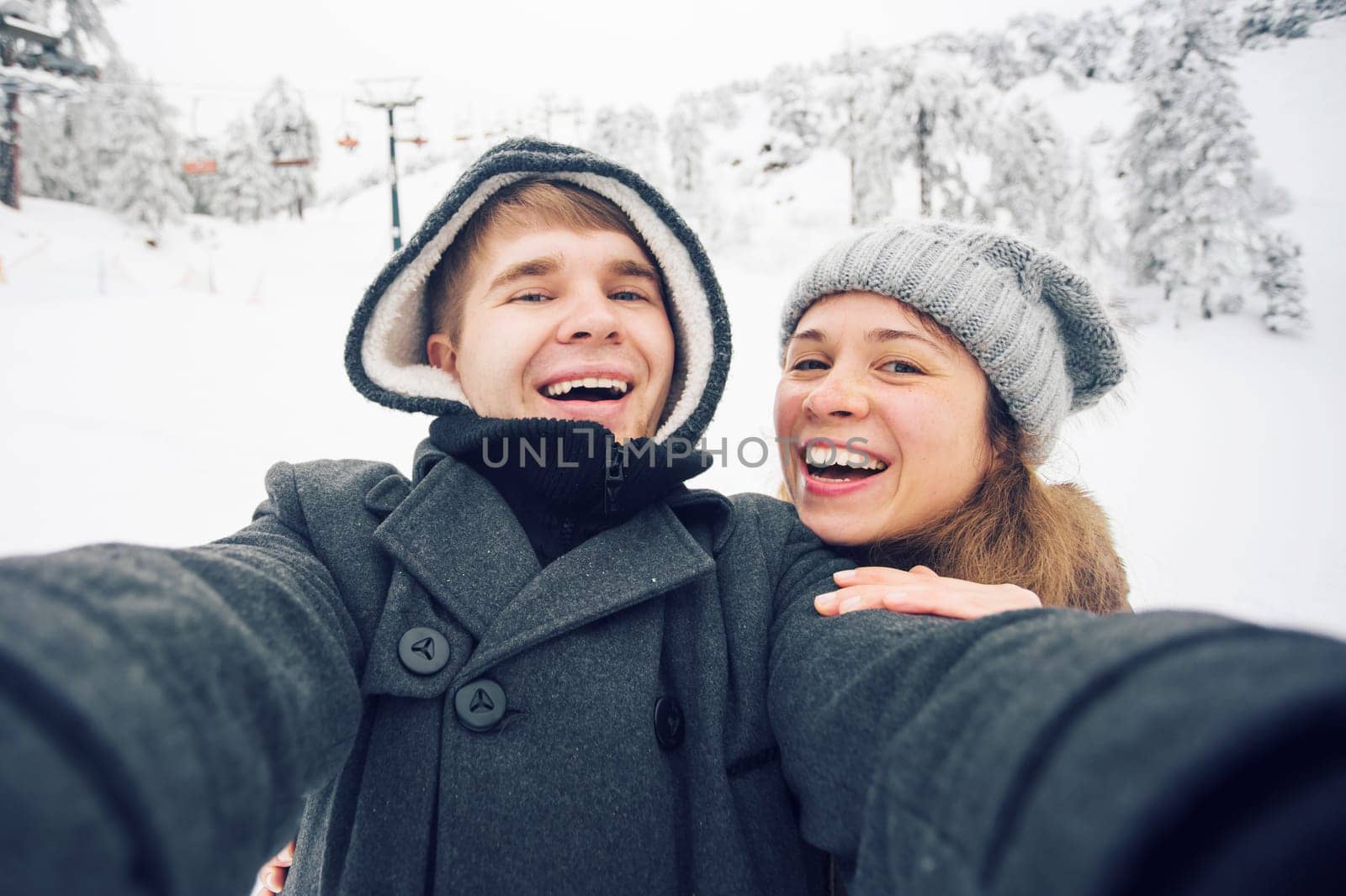 Young and happy couple doing winter selfie outdoor. Christmas, New Year and people concept.