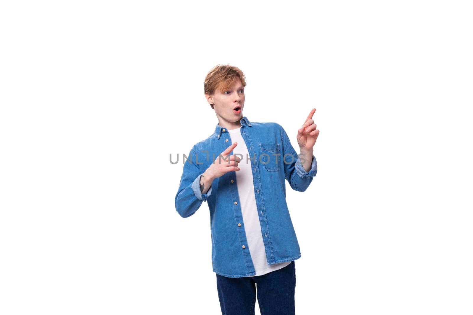 portrait of a european red-haired student guy dressed in a blue denim shirt on a white studio background by TRMK