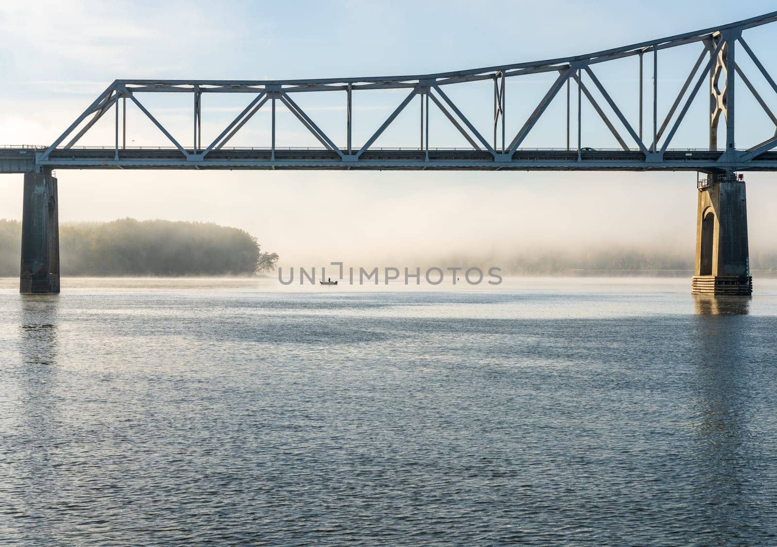 Fisherman fishing in Mississippi river on misty autumn morning by steheap