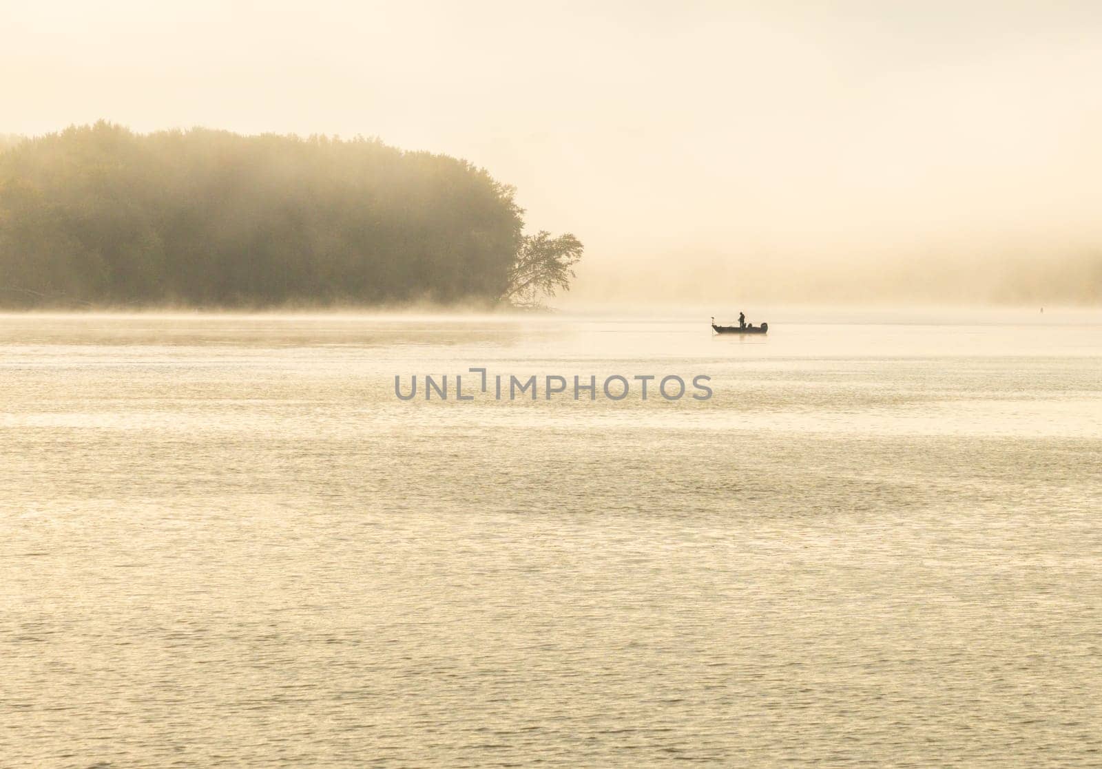 Fisherman fishing in Mississippi river on misty autumn morning by steheap