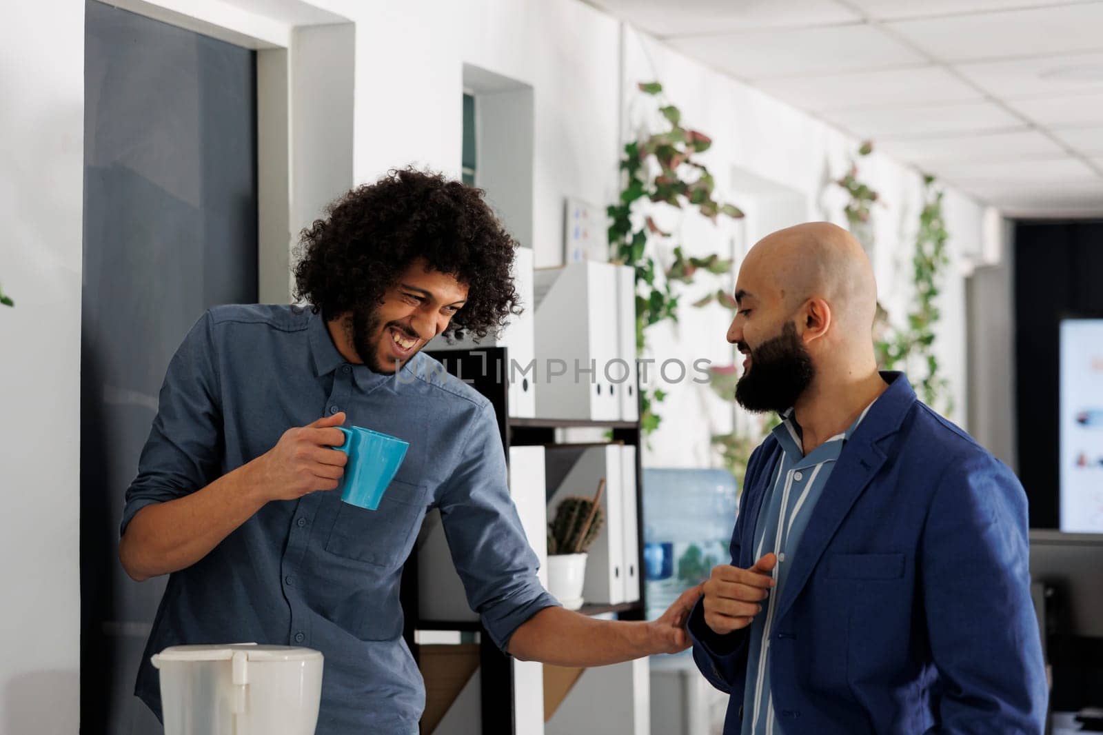 Corporate colleagues telling joke and laughing while drinking coffee by DCStudio