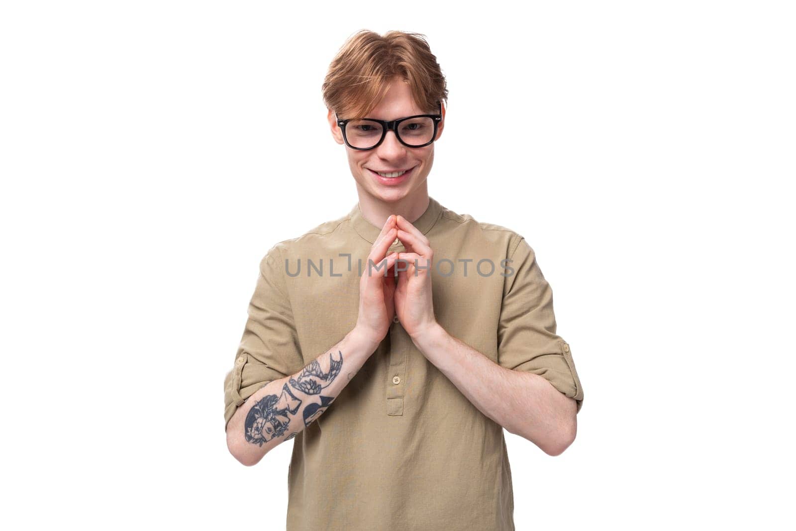 young cute caucasian guy with red hair with a tattoo on his arm in a brown shirt by TRMK
