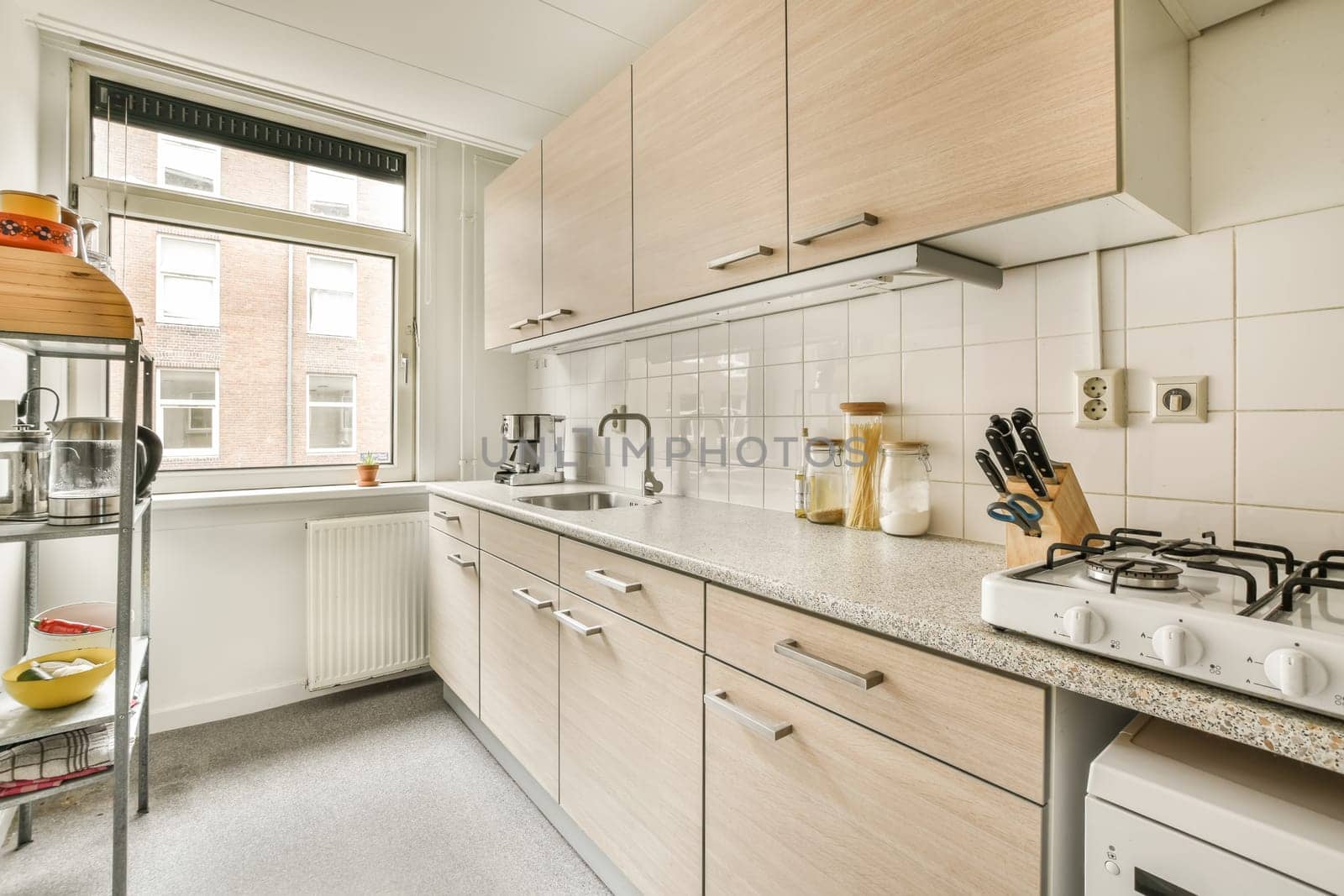 a white kitchen with wooden cabinets and a counter top by casamedia