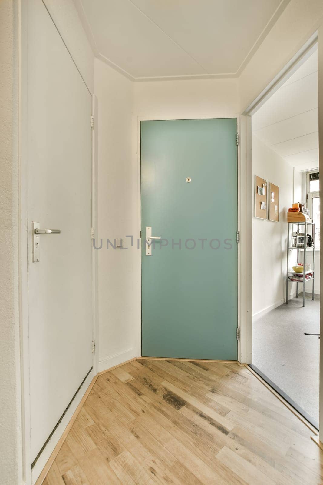 a room with a green door and a wooden floor by casamedia