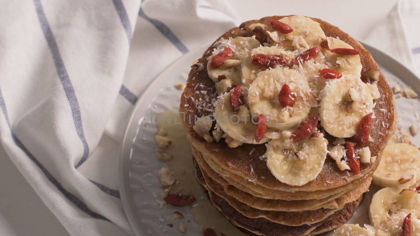 Healthy breakfast table,  homemade pancakes with banana, goji and walnuts.