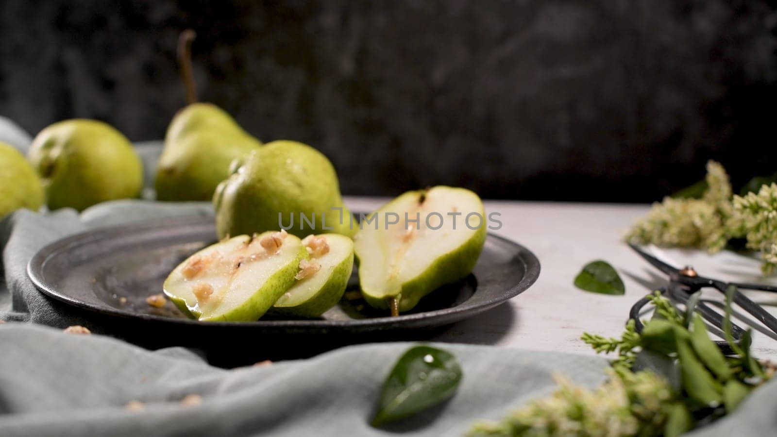 Metal plate with delicious ripe pears on table.