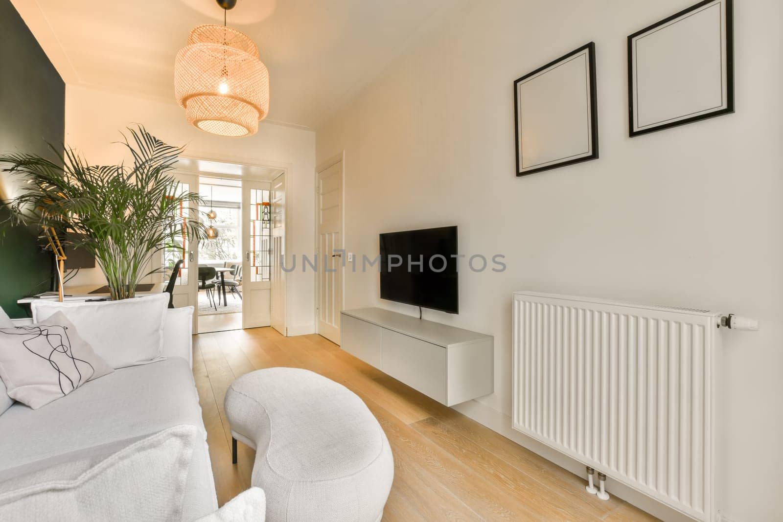 a living room with two white chairs and a television on the wall in front of the tv is mounted to the wall