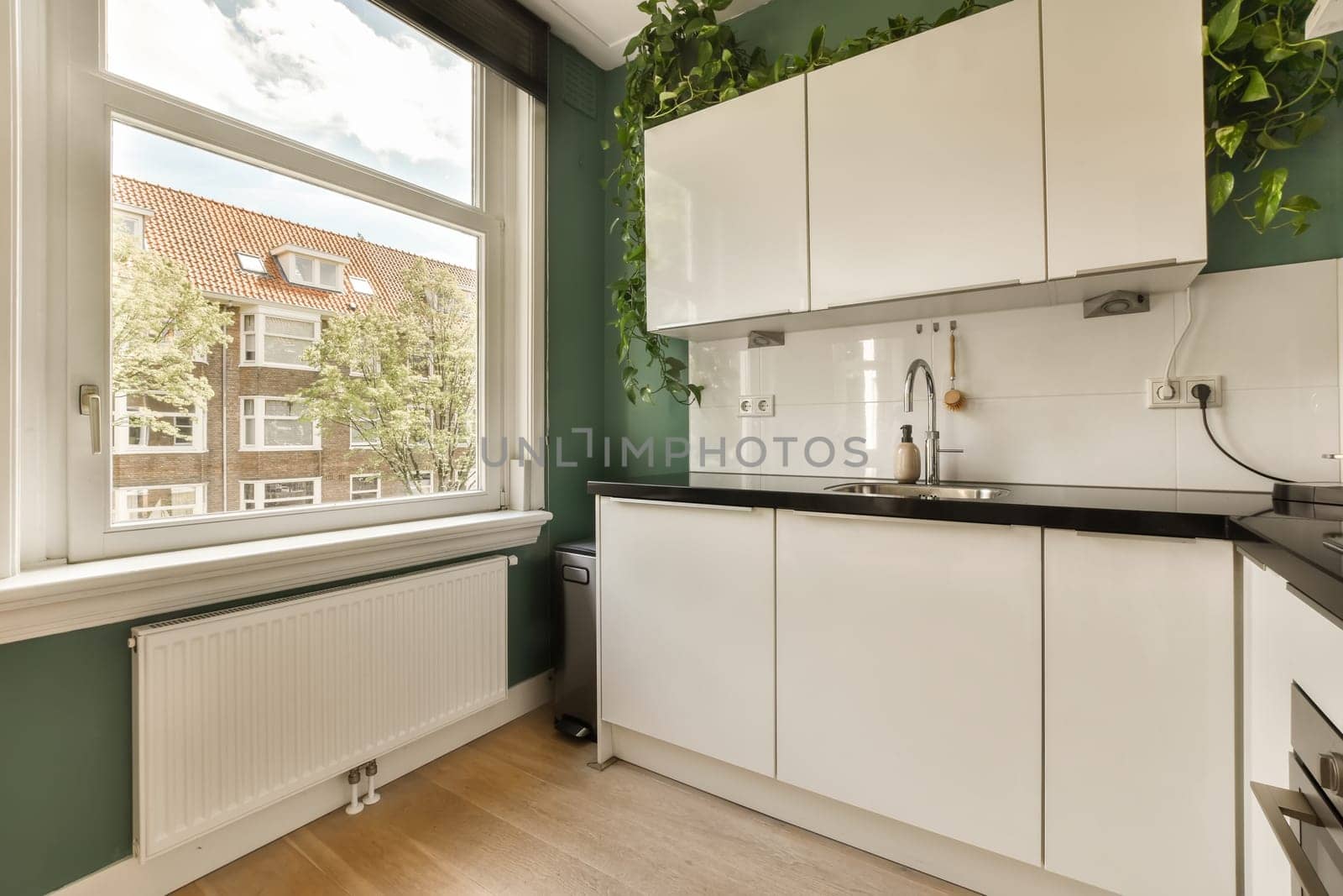 a kitchen with white cabinets and a large window by casamedia