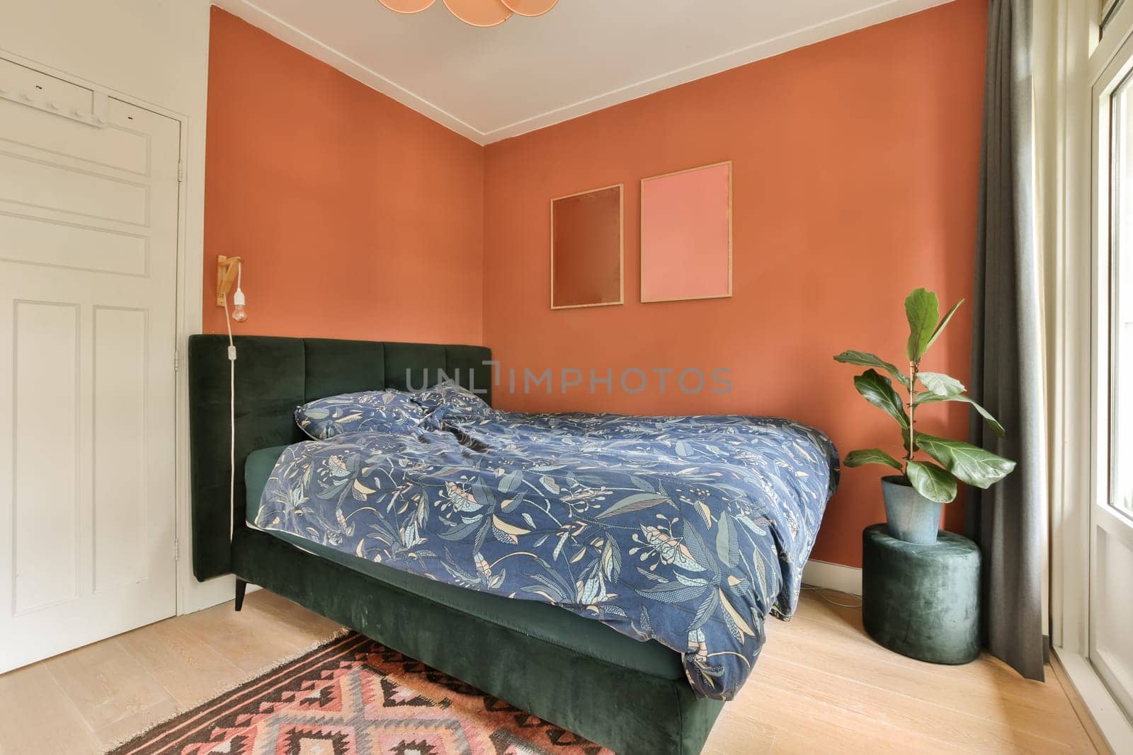 a bedroom with orange walls and a green bed by casamedia