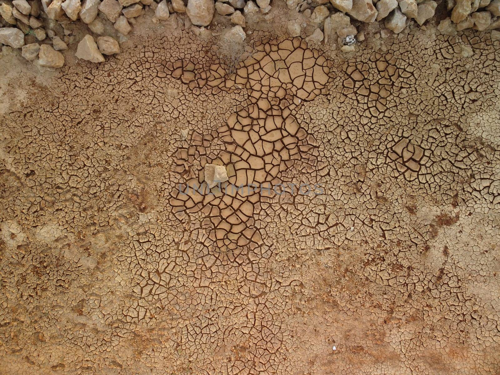 Aerial top down view on dry cracked red soil. arid, cracked red soil drought and arid climate conditions. Climate and weather change