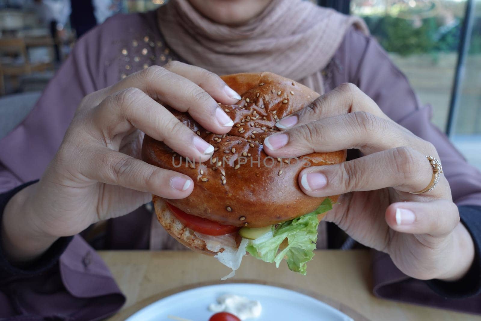 women hand holding beef burger .