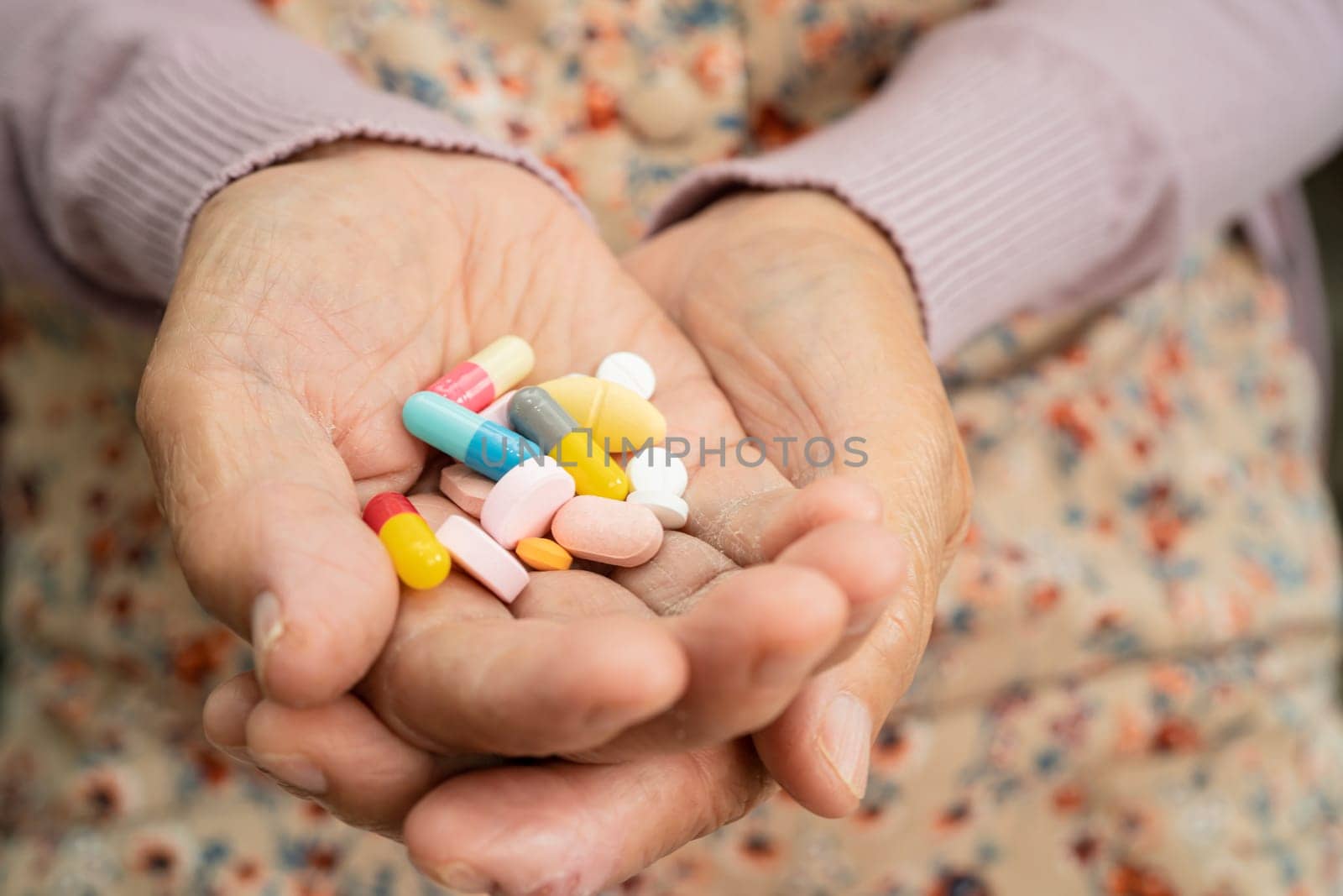 Asian senior woman patient holding antibiotics capsule pills  for treatment infection patient in hospital, Pharmacy drugstore concept.