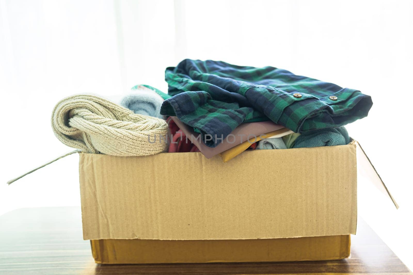 Donation box with used clothes at home to support help for poor people in the world. by pamai