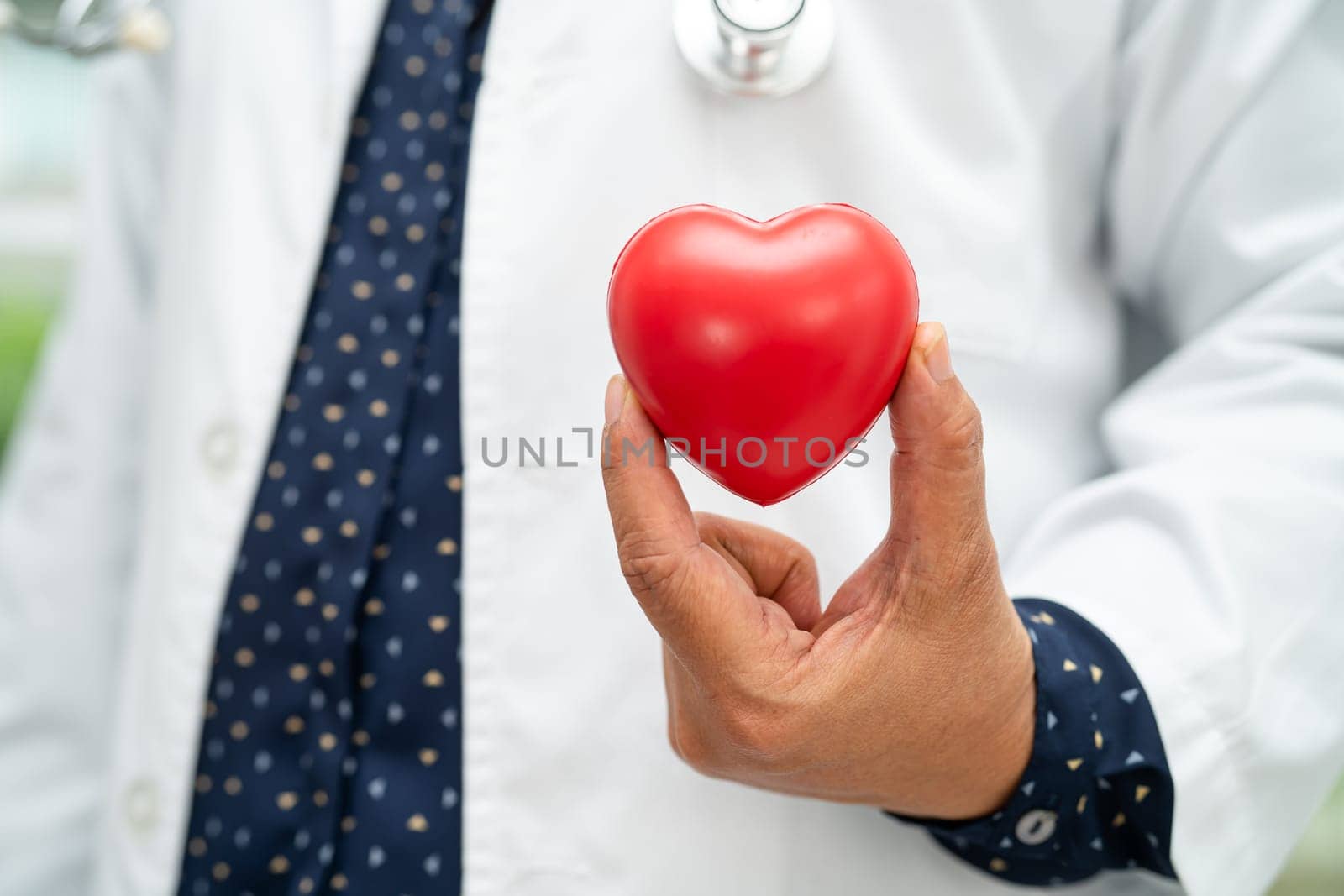 Doctor holding a red heart in hospital ward, healthy strong medical.