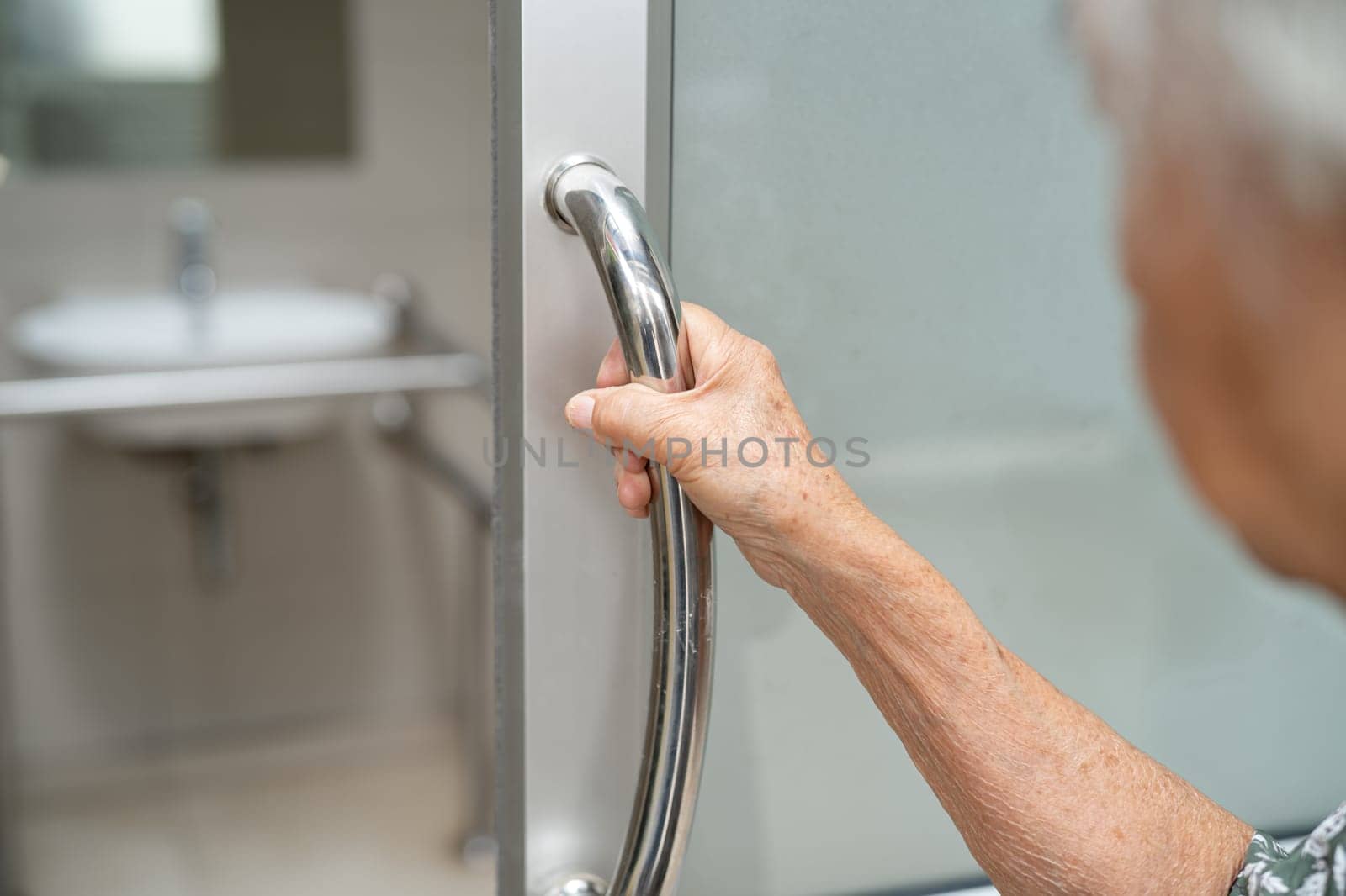 Asian elderly woman patient use toilet bathroom handle security in nursing hospital, healthy strong medical concept.