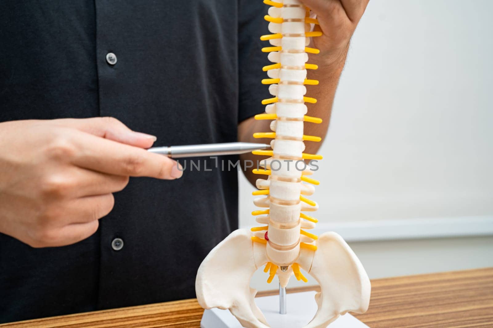 Student teenage learning anatomy biology with bone human body model in classroom at high school.