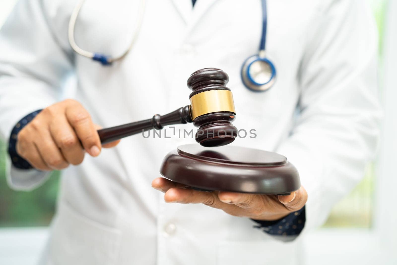 Doctor holding judge gavel, forensic medicine, medical law and crime justice concept.