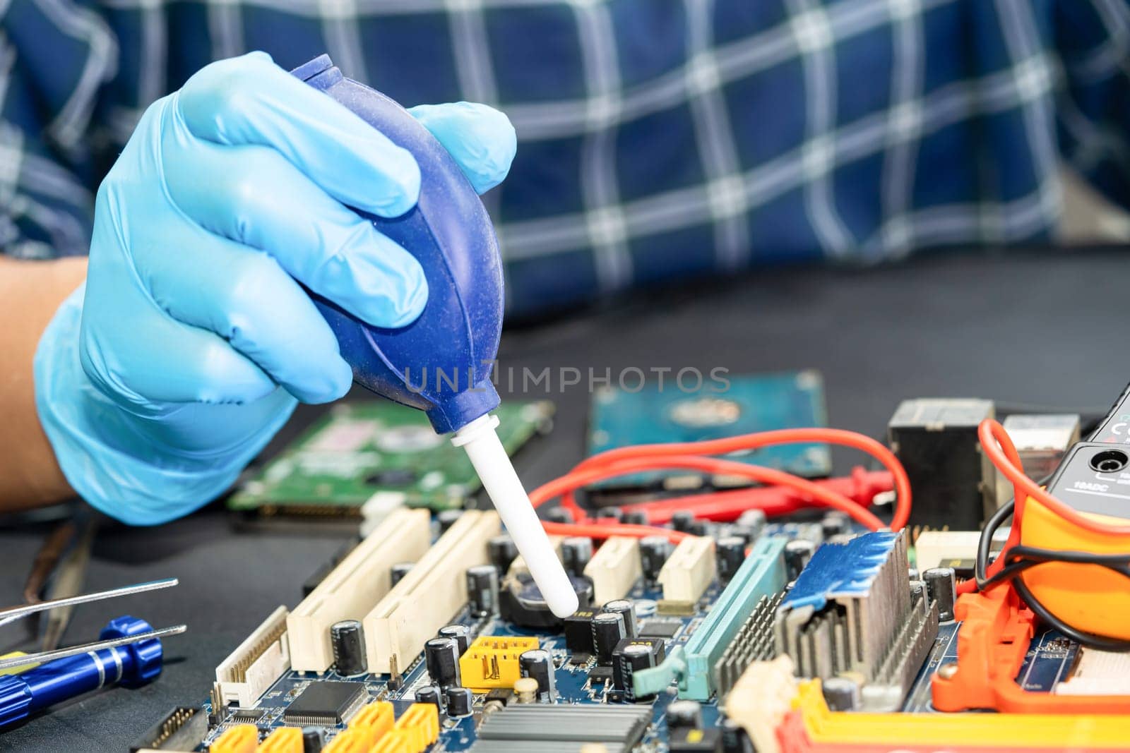 Asian technician repair and cleaning dirty micro circuit main board of smartphone electronic technology with brush, hardware, mobile phone, upgrade concept. by pamai