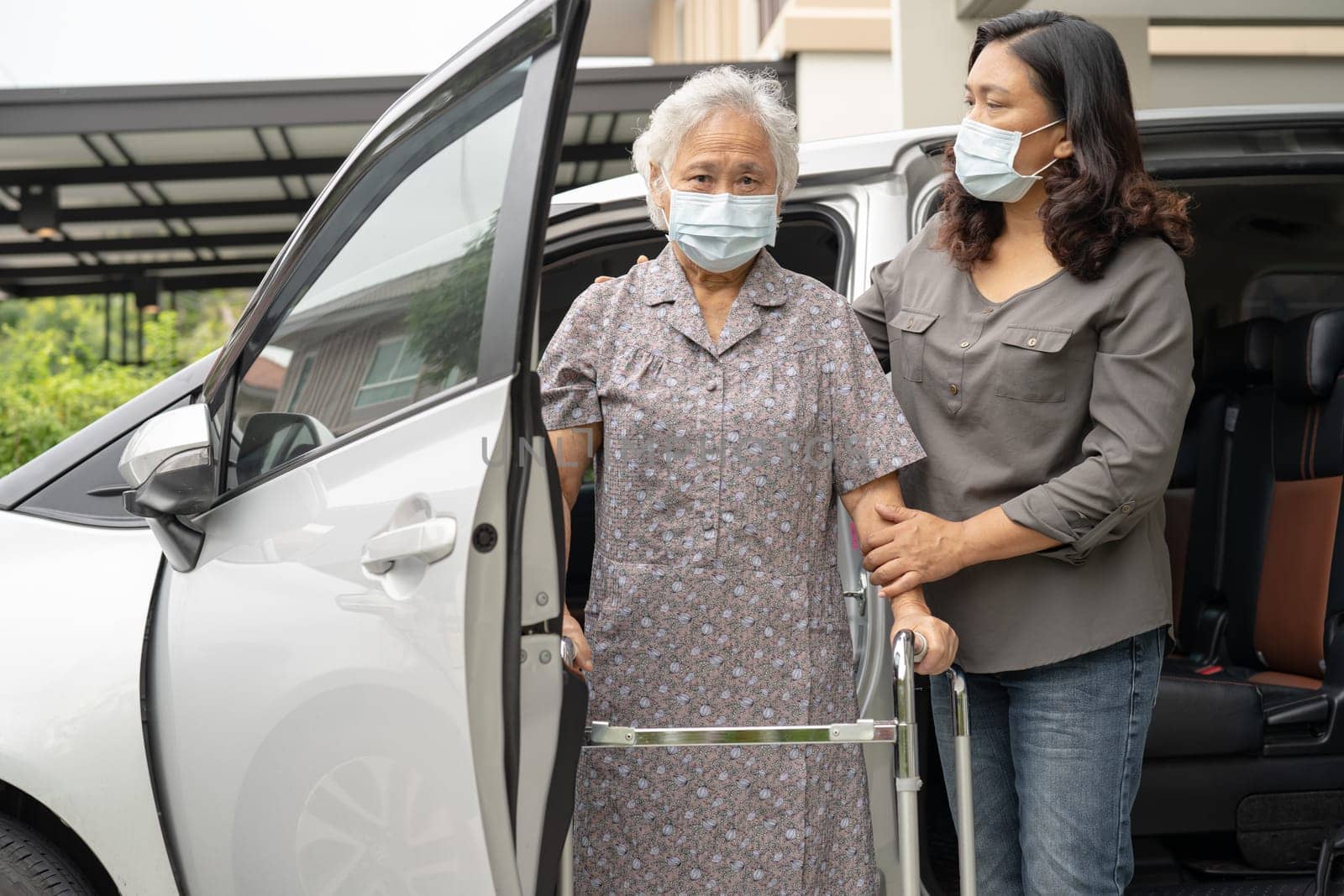 Asian senior woman patient walk with walker prepare to get her car. by pamai