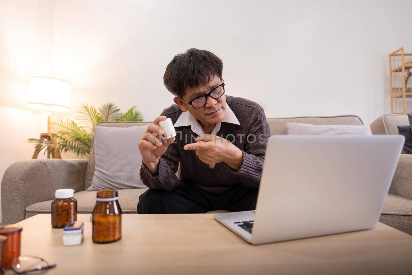 Asian Mature adult man having video call consulting with doctor medicine on laptop from home, telehealth or telemedicine concept.