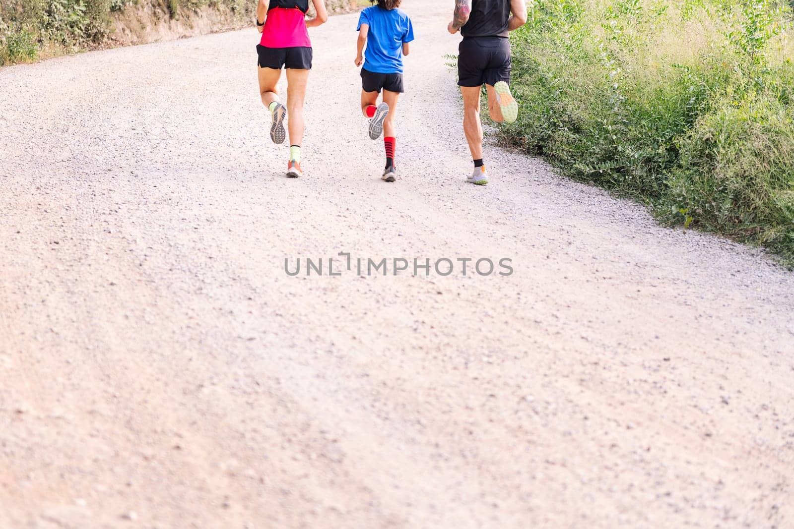 unrecognizable family running in the countryside by raulmelldo