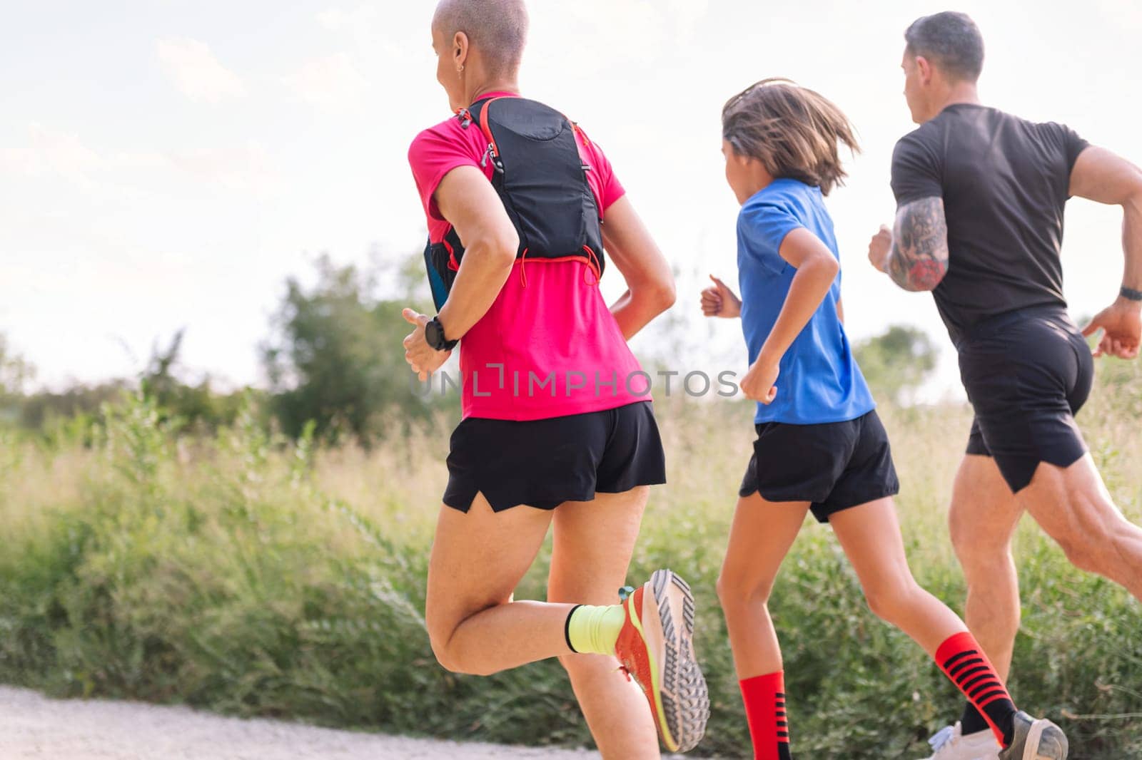 rear view of a sporty family running in the nature by raulmelldo