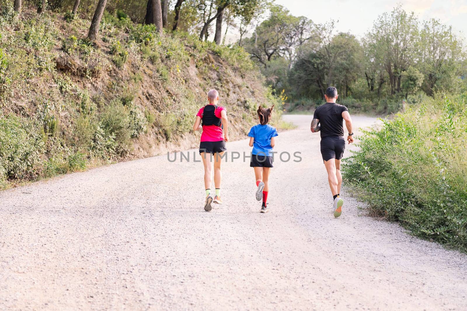 rear view of a sporty family running in the nature by raulmelldo