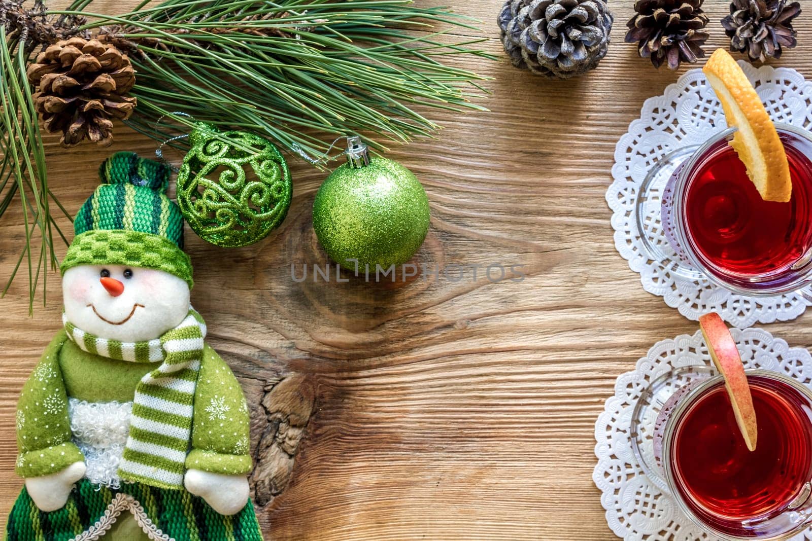 Hot mulled wine with spices on wooden background. Christmas tree branches, gifts and cones. Flat lay, copy space, top view. Holidays.