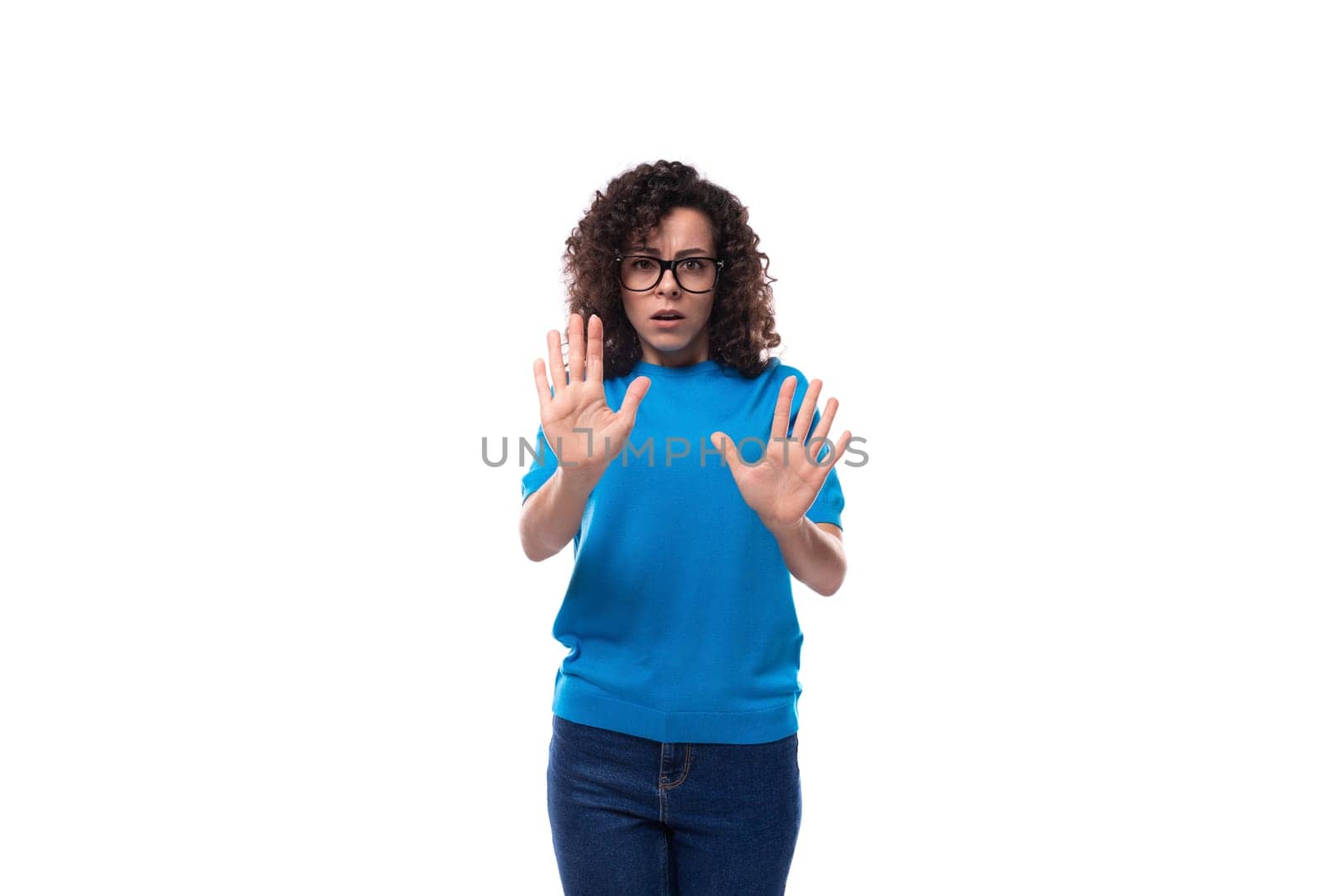 portrait of a young woman with curly hair dressed in a blue t-shirt working in the field of advertising on a studio background by TRMK